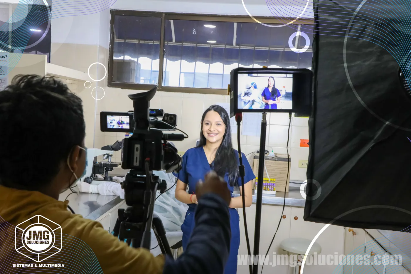 Camarógrafo de JMG graba a una profesional de la salud en un set con luz suave y monitor de referencia.