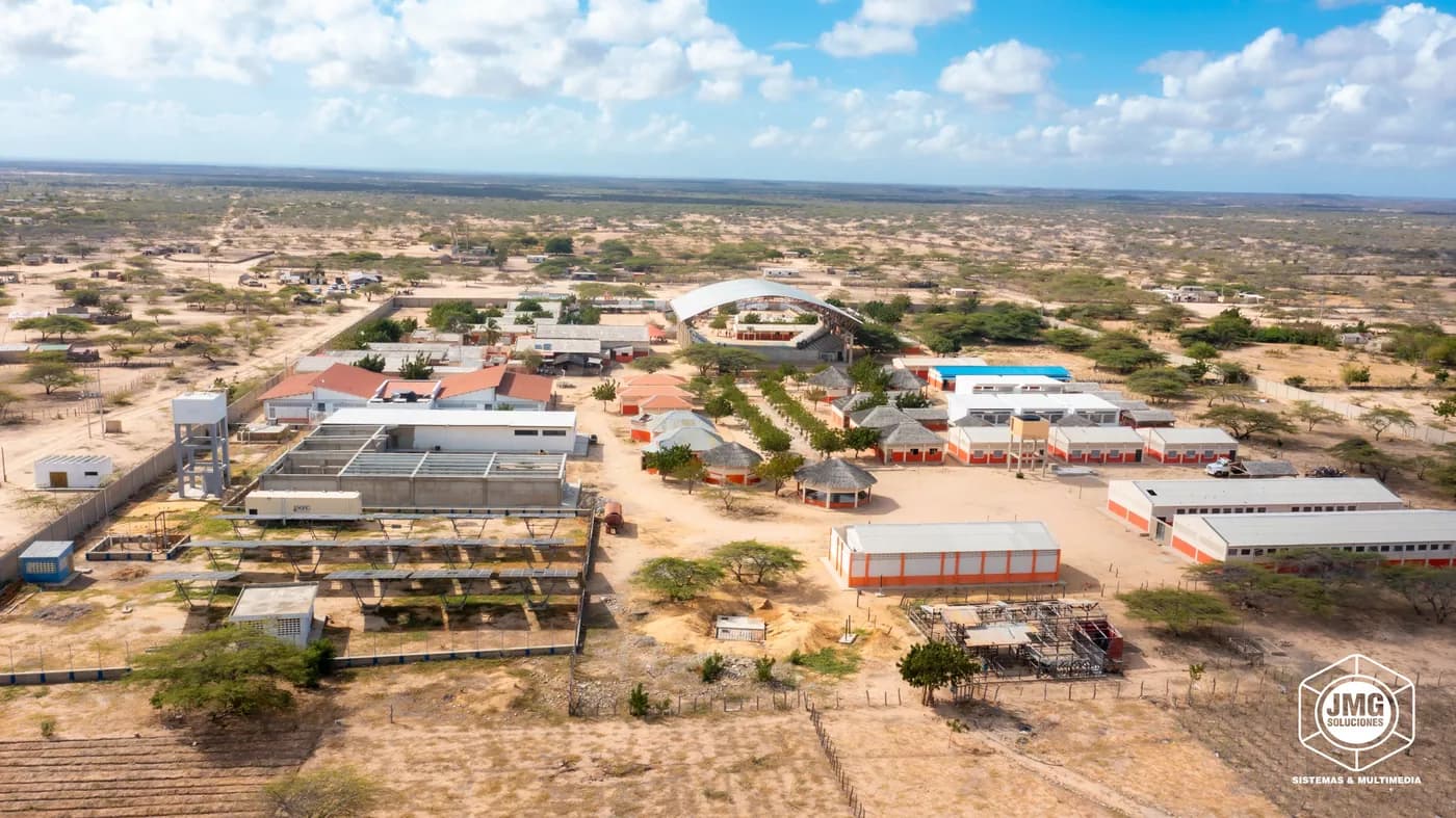 Vista aérea con dron de un complejo de edificaciones con cubiertas y canchas en una zona semidesértica.
