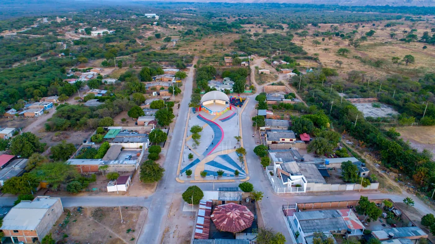 Vista aérea con dron de una plaza urbana con caminos de colores y las calles a su alrededor.
