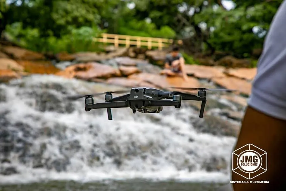 Dron de JMG en vuelo sobre una cascada, con el agua desenfocada al fondo.