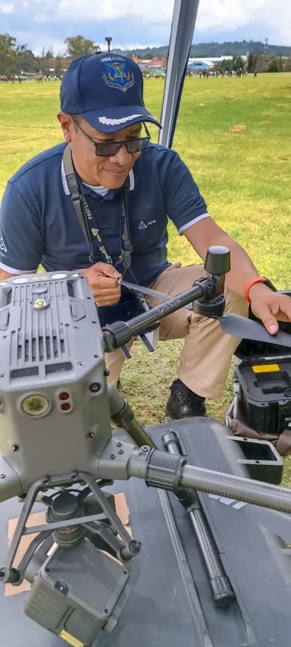 Jaider Mengual monta una hélice en un dron profesional apoyado sobre su maleta de transporte.