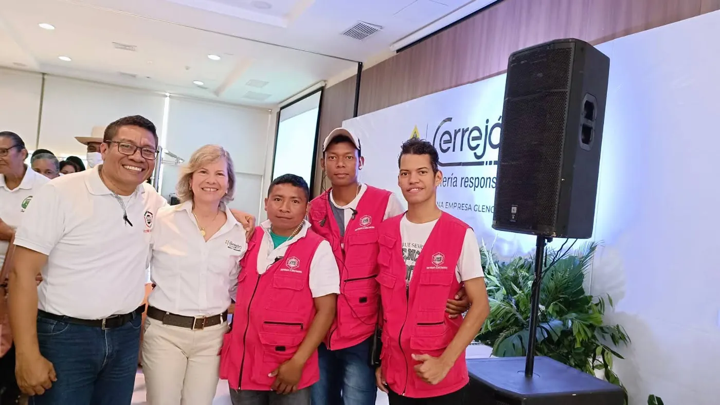Equipo de JMG con representantes de Cerrejón en un evento corporativo, junto al pendón «Cerrejón, minería responsable».