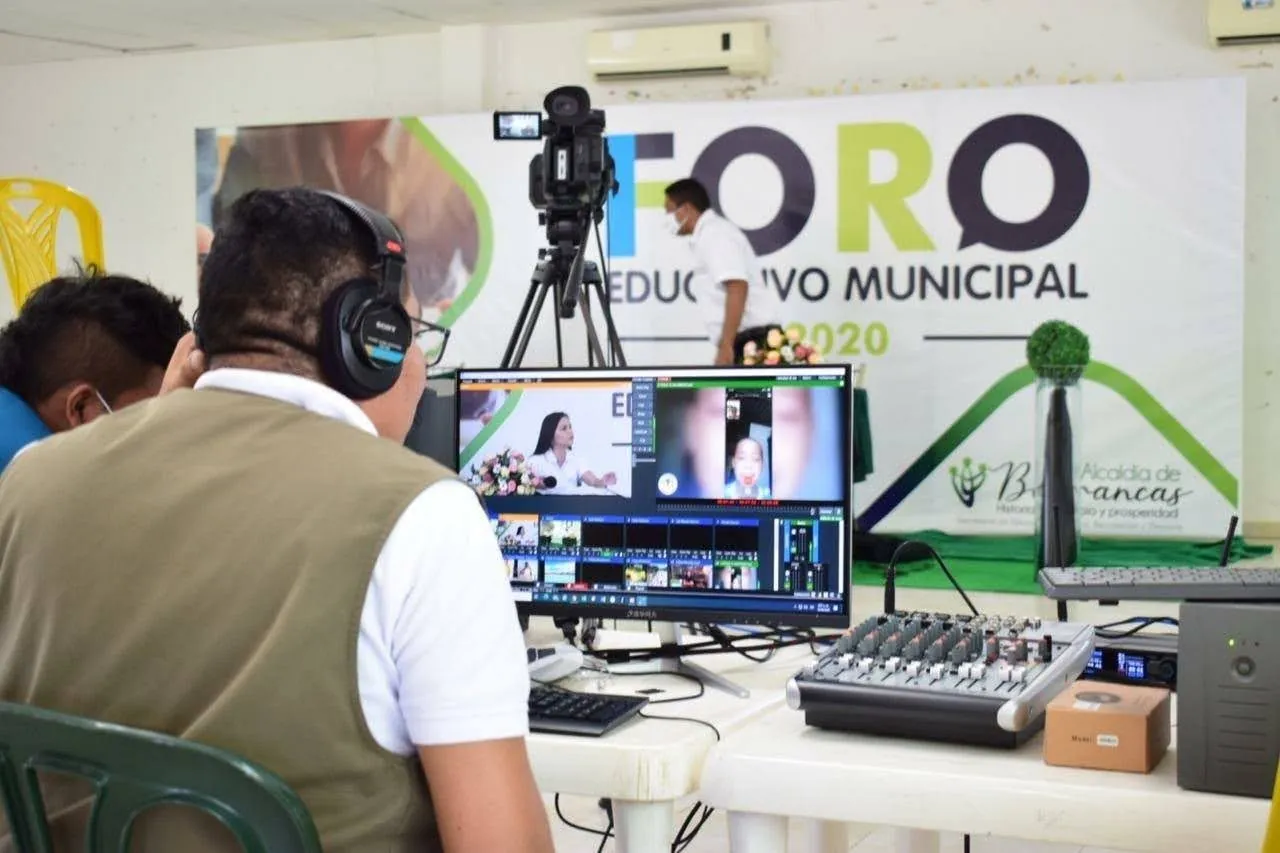 Operador de JMG transmite el Foro Educativo Municipal 2020 desde una mesa de control con mezclador y monitor.